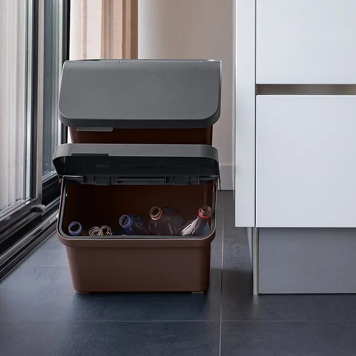Sunware Sigma home Mülltrennsystem - 45 l, L x B x H: 49,3 x 38,8 x 29,8 cm, Schoko, Kunststoff - Stapelbare braune Recyclingbehälter mit dunkelgrauen Deckeln, einer offen mit Plastikflaschen, drinnen platziert.