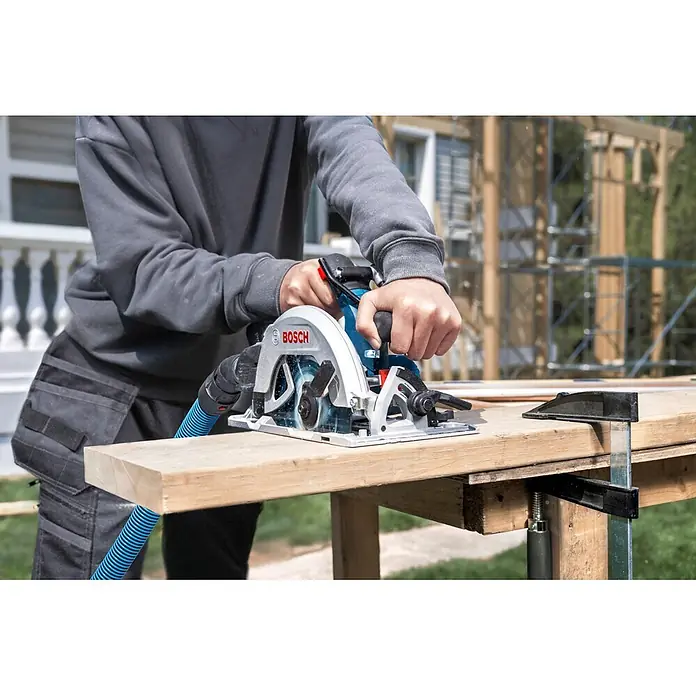 Bosch Professional AMPShare 18V Akku-Handkreissäge GKS 18V-68-2 SOLO - 19 V, Ohne Akku, Durchmesser Sägeblatt: 190 mm, 5.225 U/min - 5.775 U/min - Eine Person sägt mit einer blau-silbernen Bosch-Kreissäge ein Holzbrett auf einer Werkbank.
