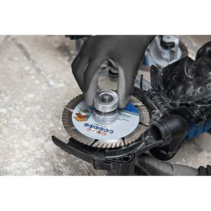 Bosch Professional AMPShare 18V Akku-Mauernutfräse GNF18V-40 - 18 V, Ohne Akku, Durchmesser Schleifscheibe: 150 mm - Behandschuhte Hand montiert eine Diamant-Trennscheibe (Ø150mm) auf ein Elektrowerkzeug.