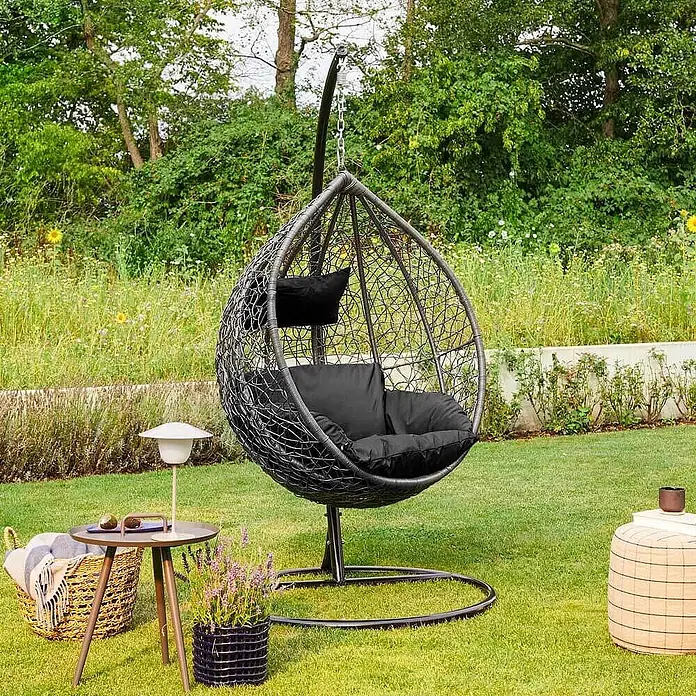 Home Deluxe Hängesessel CIELO inkl. Regenabdeckung - Kunststoff, Schwarz - Ein dunkelgrauer Rattan-Hängesessel mit schwarzen Kissen, ideal zum Entspannen im Freien.