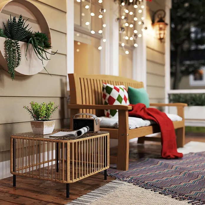 Outsunny Garten-Beistelltisch - L x B x H: 65 x 65 x 43 cm, Stahl, PE-Rattan, gehärtetes Glas, Quadratisch, Naturholz - Gemütliche Veranda mit Holzbank, gemusterten Kissen, roter Decke und Rattan-Tisch mit Pflanze. Lichterketten erhellen die Szene.