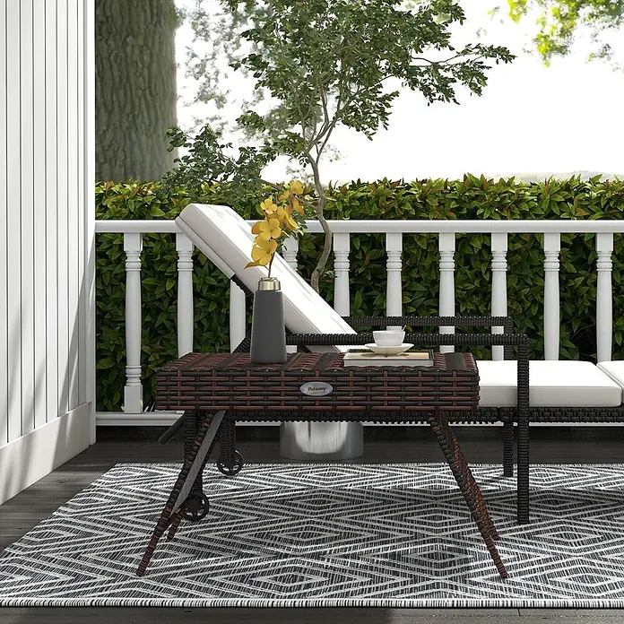Outsunny Garten-Beistelltisch - Verzinkter Stahl, PE-Rattan, Klappbar, Rechteckig, Braun - Brauner geflochtener Outdoor-Grillwagen mit Rädern, mit Vase und Tasse, auf einer Terrasse.