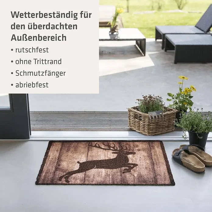 Akzente Fußmatte Listen - Mehrfarbig, Motiv / Muster|Tiere - Braune Fußmatte mit Holzplanken-Optik und dunkler Silhouette eines springenden Hirsches, am Terrasseneingang platziert.