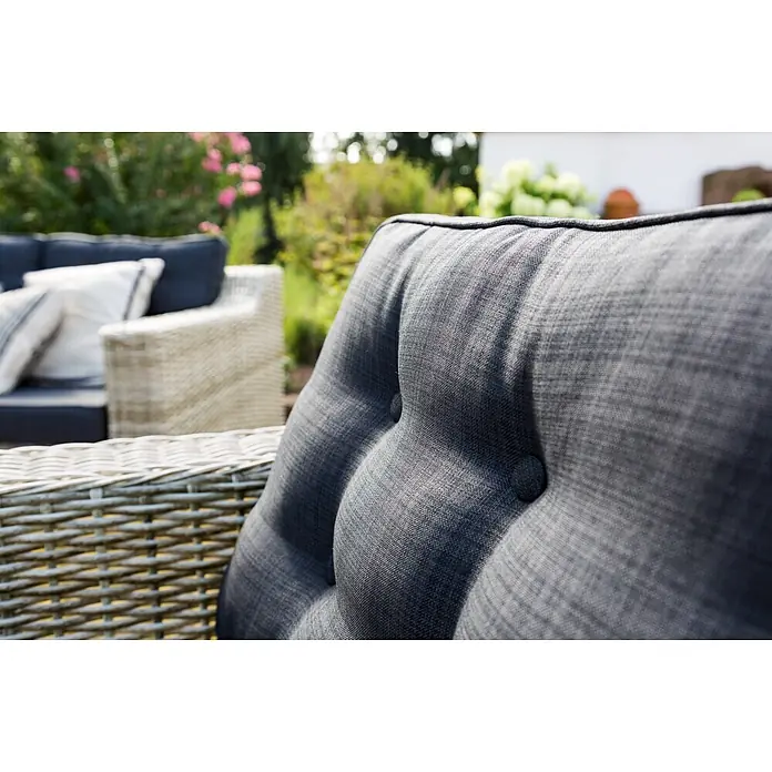 Sunfun Pauline Loungemöbel-Set XXL - 4 -tlg., Polyrattan, Bambusgrau/Anthrazit - Nahaufnahme eines grauen, knopfverzierten Gartenmöbelkissens mit Rattanrahmen, das eine gemütliche und stilvolle Outdoor-Entspannung verspricht.