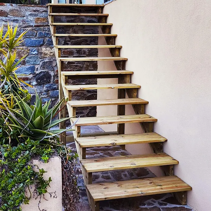 Vinuovo Außentreppe BERLIN Holztreppe - 9 Offene Stufen 156cm Höhe - 80cm Breite - Anzahl Steigungen: 9 Stk., Gerade - Helle Holztreppe im Freien, die an einer Wand emporführt.