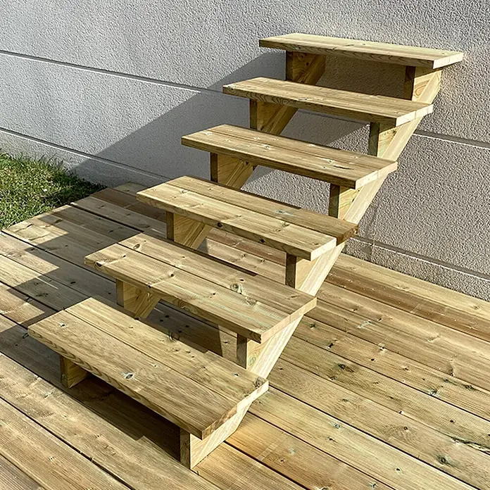 Vinuovo Außentreppe BERLIN Holztreppe - 6 Offene Stufen 105cm Höhe - 80cm Breite - Anzahl Steigungen: 6 Stk., Gerade - Modulare Outdoor-Holztreppe mit heller, natürlicher Oberfläche, die eine Terrasse mit einer Wand verbindet.