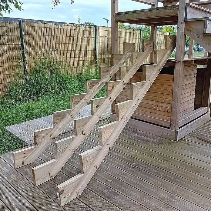 Vinuovo Außentreppe 3er Set Treppenwange 8 Stufen aus KDI Holz für Gartentreppen-Höhe 136cm - Anzahl Steigungen: 8 Stk., Gerade - Helle Holztreppe führt zu einem Spielhaus auf einer Terrasse.
