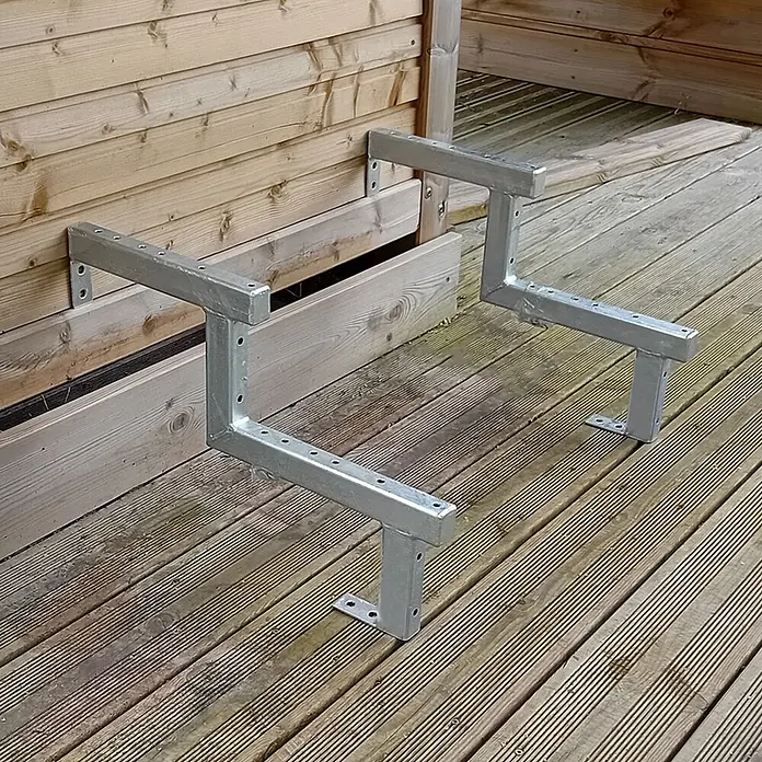 Vinuovo Außentreppe 2er Set Stahl Treppenwange 2 Stufen - Option für Setzstufen-Höhe 34cm - Anzahl Steigungen: 2 Stk., Gerade - Zwei verzinkte Z-förmige Halterungen an einer Holzwand, ruhend auf Holzterrasse.