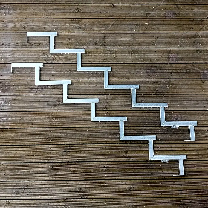 Vinuovo Außentreppe 2er Set Stahl Treppenwange 6 Stufen - Option für Setzstufen-Höhe 102cm - Anzahl Steigungen: 6 Stk., Gerade - Verzinkte Metall-Treppenwangen bilden Stufen auf einer Holzterrasse, bereit zur Treppenmontage.