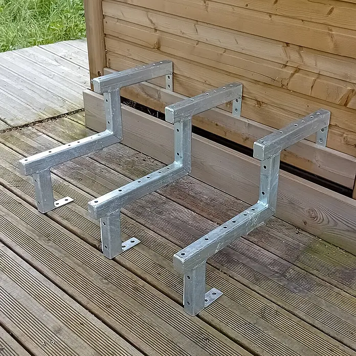 Vinuovo Außentreppe 3er Set Stahl Treppenwange 2 Stufen - Option für Setzstufen-Höhe 34cm - Anzahl Steigungen: 2 Stk., Gerade - Drei verzinkte Stahl-Wangentreppenhalterungen auf Holzterrasse, bereit zur Stufenmontage.