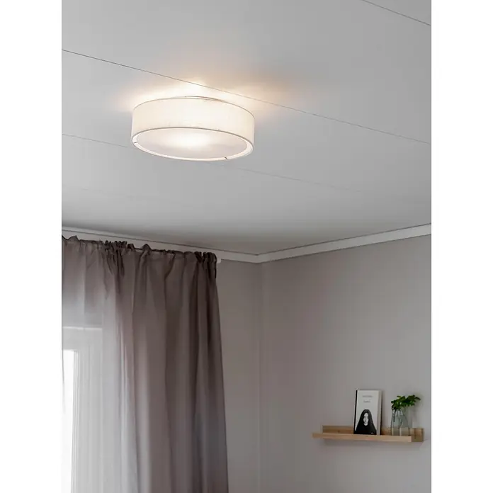 PR Home Deckenleuchte Sam - 25 W, E27 - Eine runde Deckenleuchte mit hellem Stoffschirm beleuchtet einen Raum. Sie ist bündig montiert.