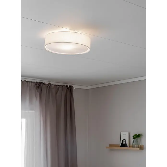 PR Home Deckenleuchte Sam - 25 W, E27 - Runde Stoffdeckenleuchte erhellt einen modernen Raum mit hellgrauen Wänden und Vorhängen.