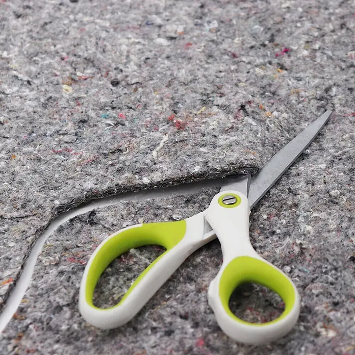 Aquagart Bodenschutzvlies 68m² 1000g/m² Teichvlies Teich Schutzvlies -  - Schere mit weiß-limettengrünen Griffen schneidet durch dickes, graues Filzmaterial.