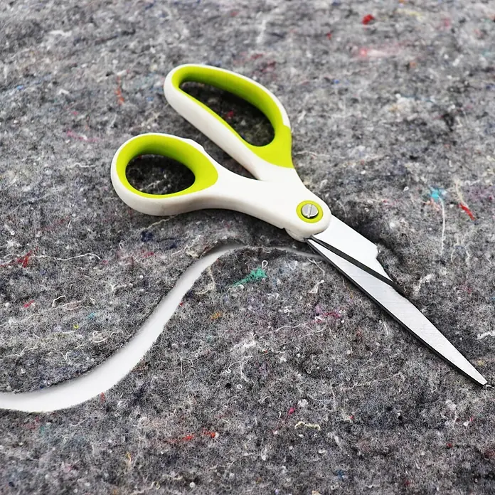 Aquagart Bodenschutzvlies 60m² 300g/m² Teichvlies Teich Schutzvlies -  - Weiß-grüne Schere schneidet dicken grauen Filz, bildet eine wellige Linie.