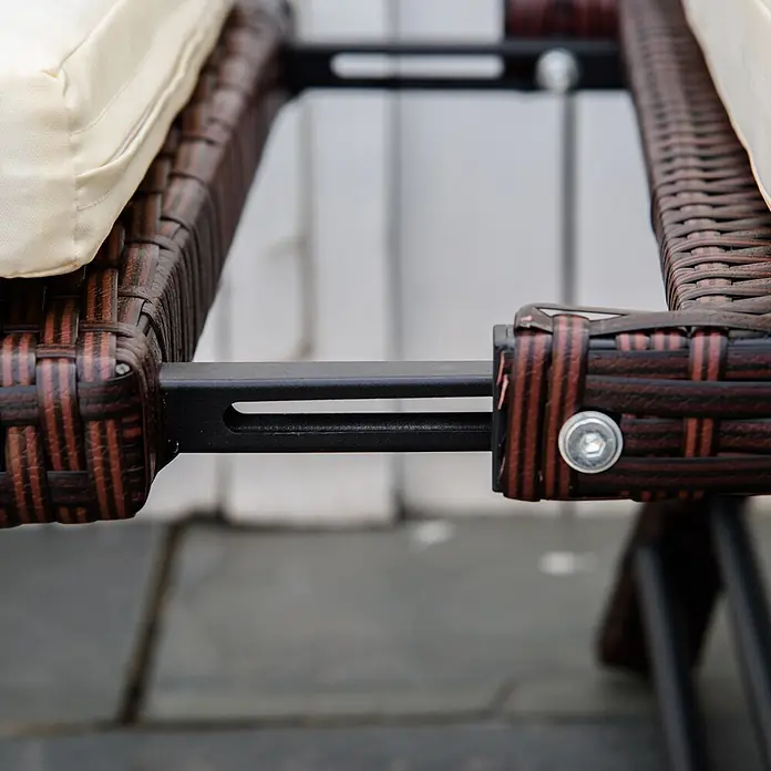 Outsunny Loungesofa - Stahl, Polyrattan, Polyester, Braun, Cremeweiß, Klappbar - Nahaufnahme brauner Rattan-Gartenmöbel mit beigem Kissen, zeigt schwarze Metallrahmenverbindung mit Silberschraube.
