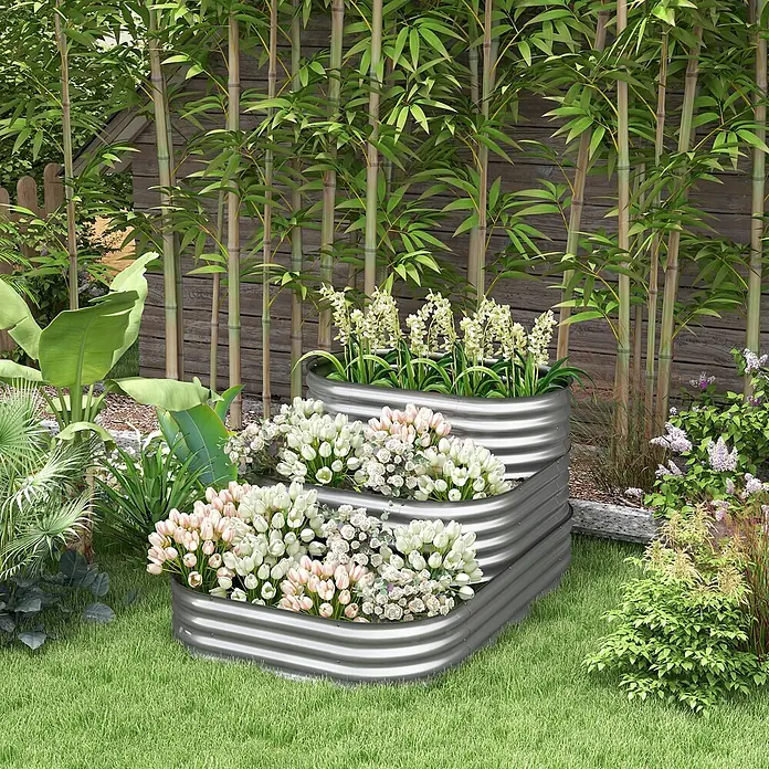 Outsunny Hochbeet - Metall, Silber - Gestuftes Hochbeet aus verzinktem Stahl, gefüllt mit Blumen, in einem Garten.