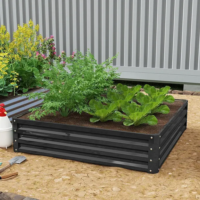 Outsunny Hochbeet - Stahl, Grau - Schwarzes Hochbeet aus Wellblech mit verschiedenen Pflanzen, darunter Salat, in einem Garten mit Gartengeräten.