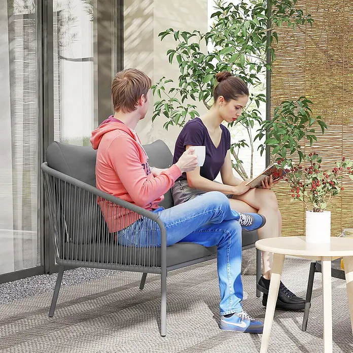 Outsunny Gartenbank - B x T x H: 72 x 72 x 76 cm, Stahl, PE-Rattan, Polyester, Schaumstoff, Grau - Zwei Personen entspannen auf einem grauen Outdoor-Sofa mit Seilgeflecht, genießen Getränke und lesen auf einer Terrasse.