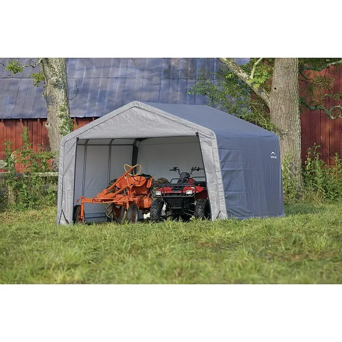 ShelterLogic Gerätehaus - Außenmaß inkl. Dachüberstand (B x T): 370 x 370 cm, Kunststoff, Grau - Hier ist ein grauer ShelterLogic-Geräteschuppen mit einem roten Traktor und einem roten ATV darin, im Freien auf einem Rasen.