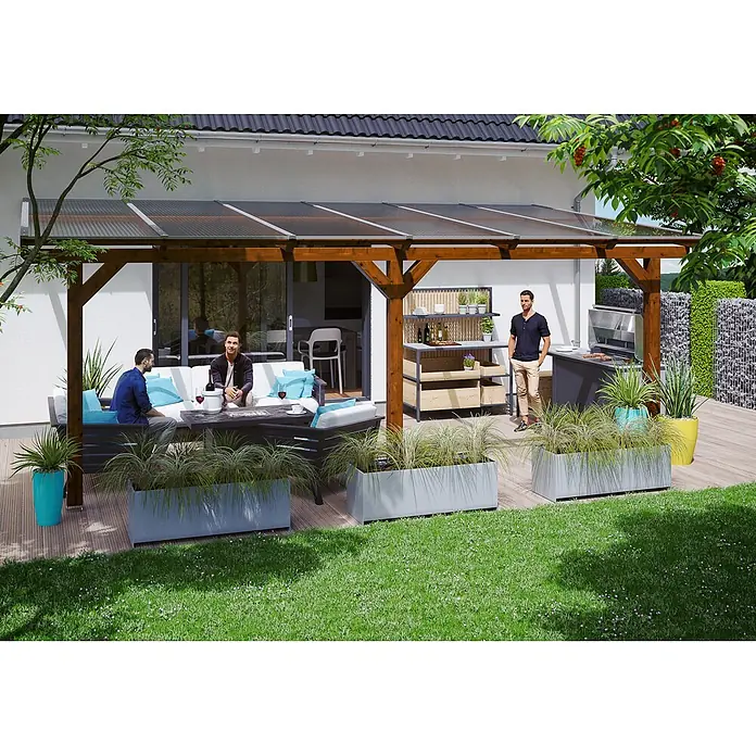 SKAN HOLZ Terrassenüberdachung Andria - B x T: 648 x 350 cm, Nussbaum, Polycarbonat, Transparent - Eine Holzpergola mit transparentem Wellendach, die vom Haus aus einen Outdoor-Wohnbereich mit Möbeln und Grillplatz schafft.