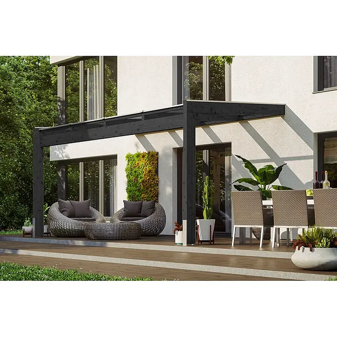 SKAN HOLZ Terrassenüberdachung Novara - B x T: 450 x 259 cm, Anthrazit, Polycarbonat, Transparent - Eine schwarze Holzpergola erstreckt sich von einem weißen modernen Haus und beschattet eine Außenterrasse mit stilvollen Möbeln.