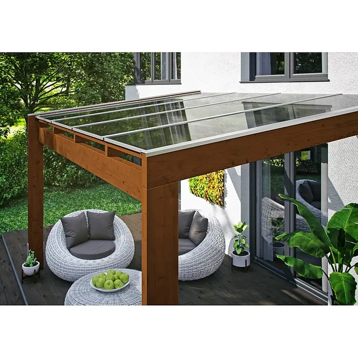 SKAN HOLZ Terrassenüberdachung Novara - B x T: 557 x 359 cm, Nussbaum, Polycarbonat, Transparent - Braune Holzpergola mit transparentem Dach, die einen Sitzbereich im Freien neben einem Haus überdacht.