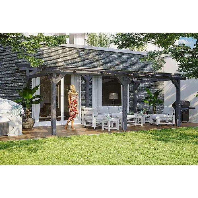 SKAN HOLZ Terrassenüberdachung Siena - B x T: 648 x 350 cm, Schiefergrau, Polycarbonat, Transparent - Dunkelgraue Holzpergola spendet Schatten über einer Außenterrasse mit Sitzgelegenheiten und einer gehenden Frau.