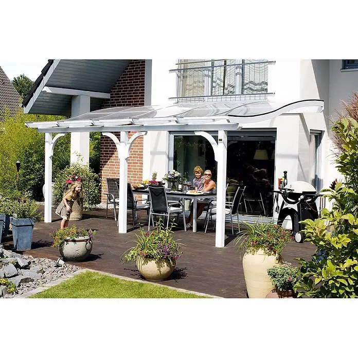SKAN HOLZ Terrassenüberdachung Venezia - B x T: 648 x 289 cm, Weiß, Polycarbonat, Transparent - Eine weiße Pergola mit gebogenem, transparentem Dach überspannt eine Holzterrasse, auf der eine Familie im Freien isst.