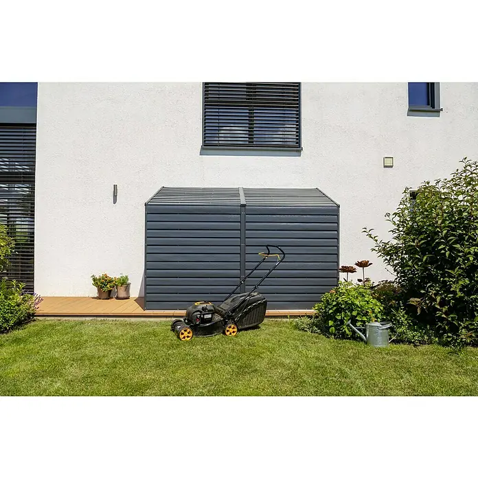 Spacemaker Gerätehaus 4x10 - Außenmaß inkl. Dachüberstand (B x T): 124,5 x 294,6 cm, Stahl, Grau - Eine Rasenmäher-Garage aus grauem Kunststoff steht vor einer weißen Hauswand mit einem Rasenmäher davor.