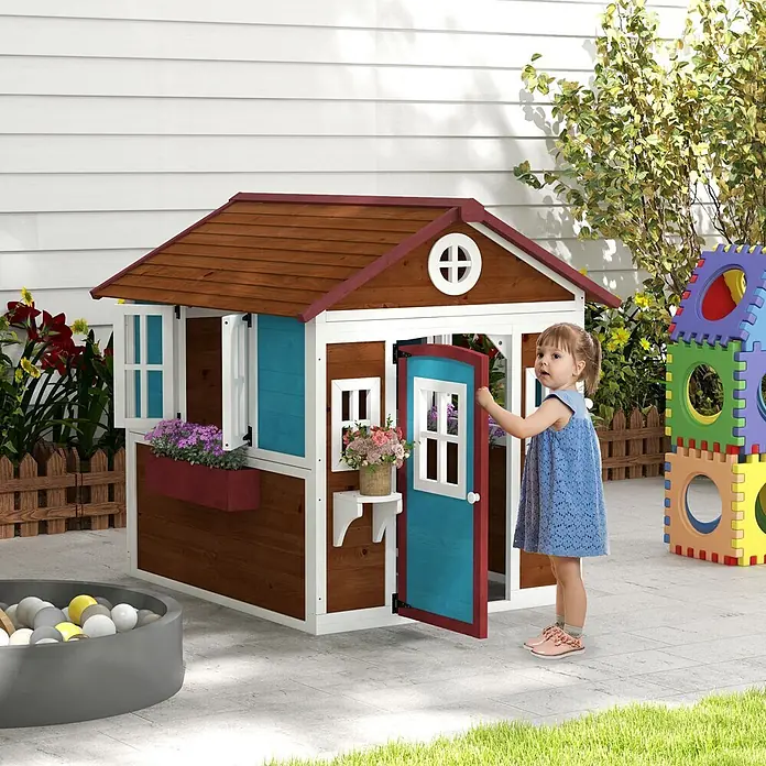Outsunny Spielhaus - L x B x H: 126,4 x 114 x 135 cm, Holz, Kaffee-Braun - Hölzernes Spielhaus für draußen mit blauer Tür und Fensterläden, roten Dachakzenten. Ein Kind öffnet die Tür, neben einem Bällebad und bunten Blöcken.