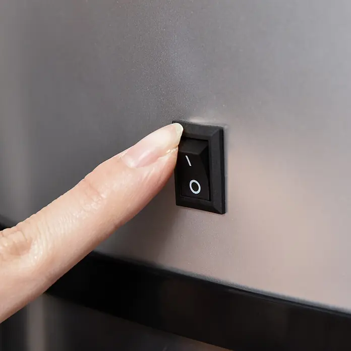 Homcom Sensormülleimer - 48 l, Stahl, Silber, Schwarz - Ein Finger drückt die "Ein"-Seite eines schwarzen Wippschalters.