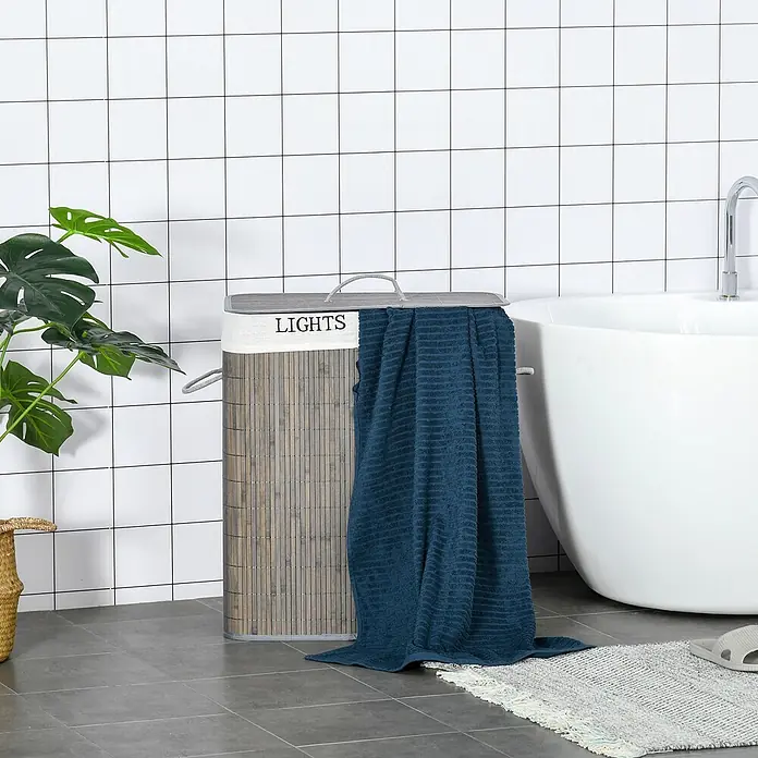 Homcom Allzweck-Korb 100l - 52 x 32 x 63 cm, Holz, Grau - Wäschekorb aus Bambusleisten mit grauem Stoffdeckel, 'LIGHTS'-Stickerei und einem dunkelblauen Handtuch darüber.