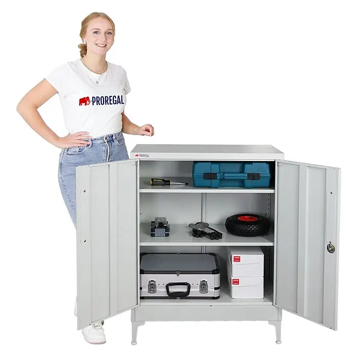 Proregal Metall-Mehrzweckschrank Mega Deal 2x ELEPHANT mit Beinen & 2 Türen, abschließbar - Lichtgrau - Grauer Metallschrank mit zwei offenen Türen, gefüllten Regalböden und einer danebenstehenden Frau.