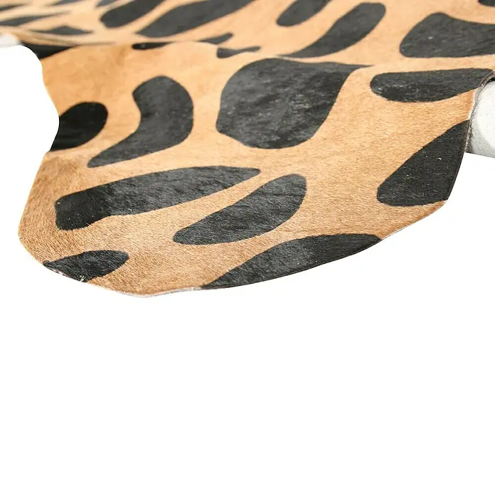 Esbeco Kuhfell - 100 % Echtfell, Giraffe - Detailaufnahme eines stilvollen Kuhfellteppichs mit auffälligem schwarz-braunem Muster, ideal für eine moderne Raumgestaltung.