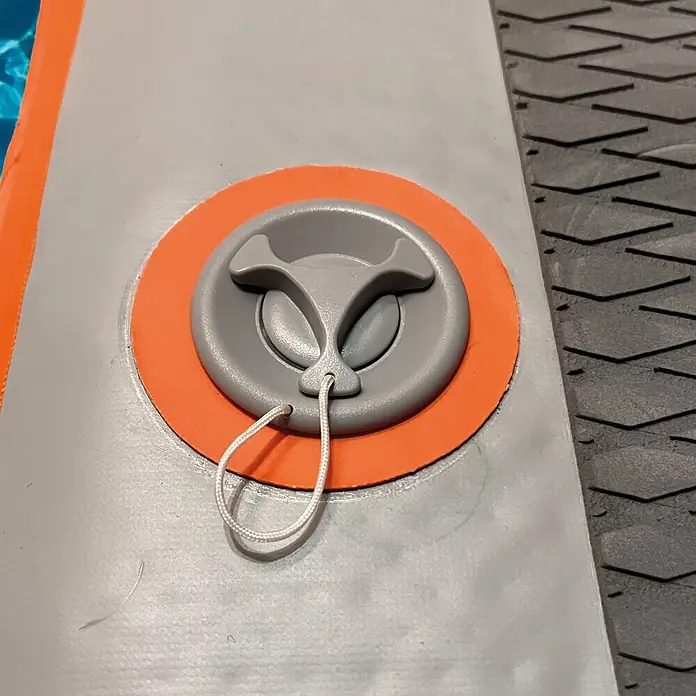 Badeleiter Dog Ramp Mini - L x B x H: 96 x 67 x 12 cm - Graues Kunststoff-Aufblasventil mit orangefarbener Basis und weißer Kordel auf einem aufblasbaren Brett.