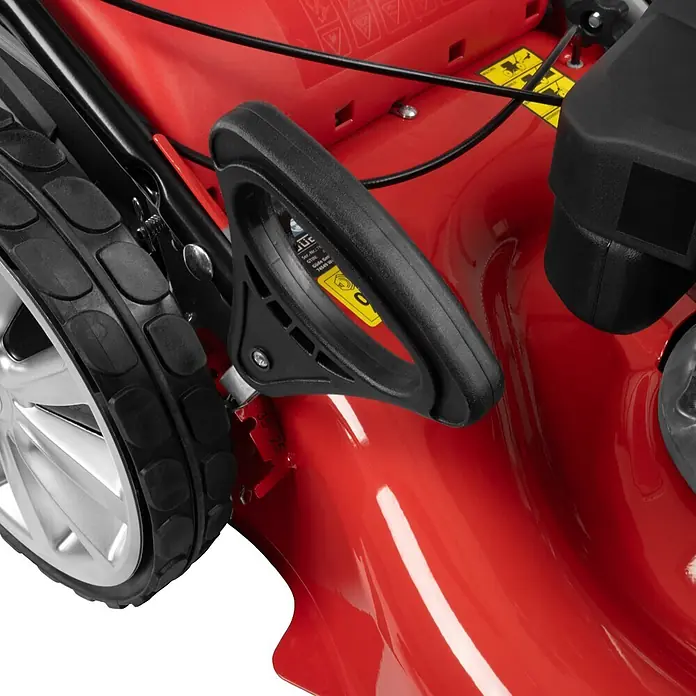 Güde Benzin-Rasenmäher 554.3R 5,03 - 3,7 kW - 5,03 kW, 196 cm³, Schnittbreite: 550 mm - Nahaufnahme eines roten Rasenmähers mit schwarzem Griff, silbernem Rad und Höhenverstellmarkierungen.