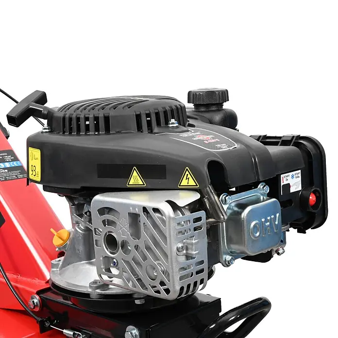 Güde Benzinmotorhacke GF 2436.1 - 2,4 kW - 3,2 kW, 139 cm³ - Nahaufnahme eines schwarz-silbernen OHV-Motors auf einer roten Gartenmaschine, mit Warnetiketten und Startergriff.