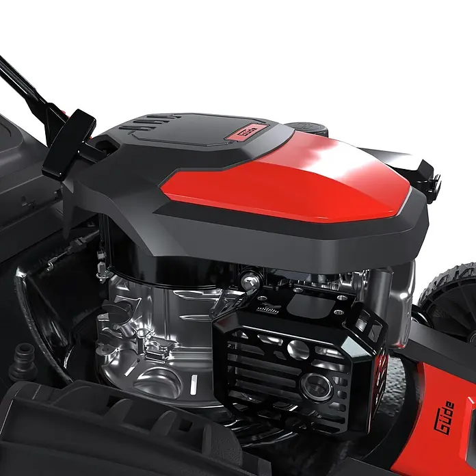 Güde Benzin-Rasenmäher Eco Wheeler 462.2R - 2,5 W - 3,4 W, 144 cm³, Schnittbreite: 460 mm - Nahaufnahme eines Güde Rasenmähermotors mit schwarzem und rotem Gehäuse, der metallische Motorkomponenten und einen Auspuffschutz zeigt.
