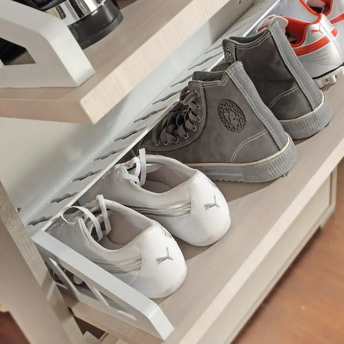 Kiamami Valentina Schuhschrank - L x B x H: 65 x 18 x 184 cm, Holz mittel - Schräge Schuhregalböden aus hellem Holz mit weißen und grauen Sneakern.