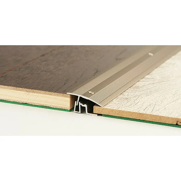 LOGOCLIC Übergangsprofil 401 - Edelstahl matt, 0,9 m x 38 mm, Montageart: Schrauben - Nahaufnahme einer silbernen Übergangsleiste zwischen zwei unebenen Fußböden, die einen sauberen und sicheren Übergang ermöglicht.