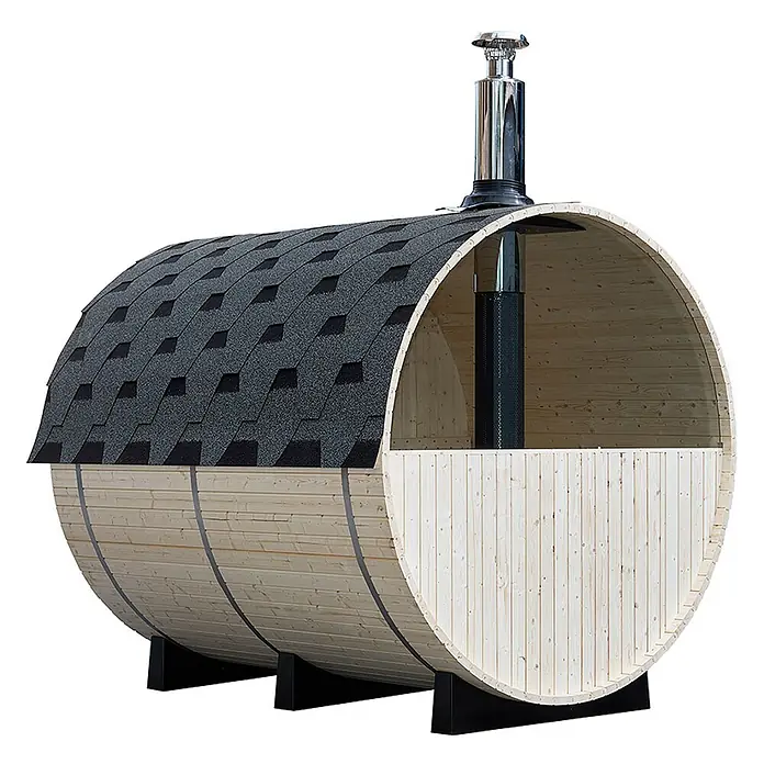 Home Deluxe Fasssauna LAGOM DELUXE - Holzofen, Holz - Eine helle Holz-Fasssauna mit dunkelgrauem Schindeldach, schwarzen Stützfüßen und einem Edelstahlschornstein.