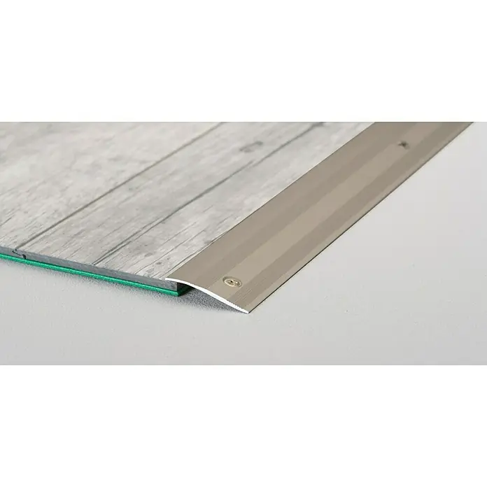 LOGOCLIC Rampenprofil 262 - Edelstahl matt, 0,9 m x 28 mm, Montageart: Schrauben - Detailaufnahme einer silberfarbenen Übergangsschiene zwischen grauem Holzboden und hellem Untergrund, befestigt mit Schrauben.