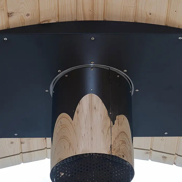 Home Deluxe Fasssauna LAGOM DELUXE - Holzofen, Holz - Schwarze Metall- und helle Holzsäule mit welliger Holzkante und perforiertem Boden, an Holzdecke montiert.