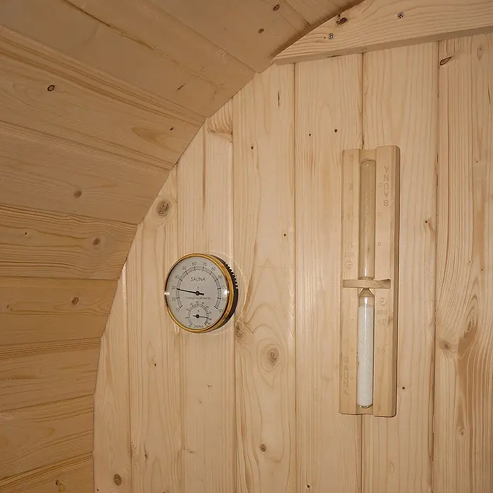 Home Deluxe Fasssauna CUBE DELUXE L - Elektroofen, Holz, L x B x H: 220 x 192,8 x 194 cm - Sauna-Thermo-Hygrometer mit Goldrand und hölzerne Sanduhr, an heller Holzwand montiert zur Überwachung von Bedingungen und Saunazeit.