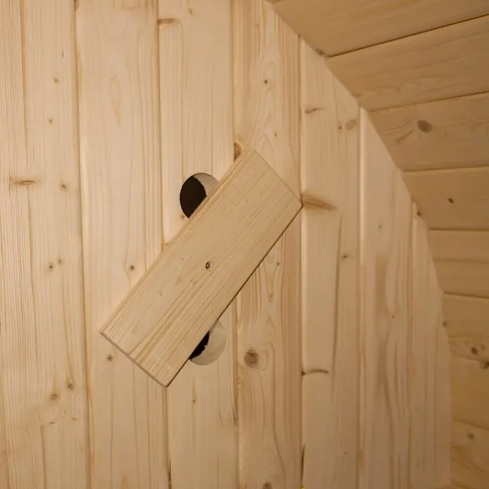 Home Deluxe Fasssauna CUBE DELUXE L - Elektroofen, Holz, L x B x H: 220 x 192,8 x 194 cm - Helle Holz-Drehlüftungsklappe an einer Holzwand mit zwei Belüftungsöffnungen.