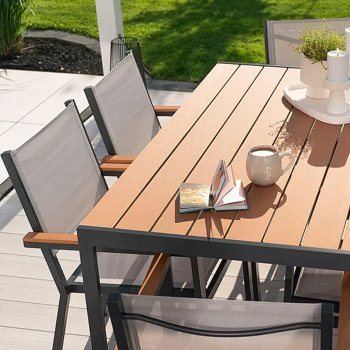 Home Deluxe Gartentisch CANTOS - L x B x H: 150 x 90 x 75 cm, Anthrazitgrau - Outdoor-Essgruppe mit braunem Lattenrosttisch, Metallrahmen und grauen Netzstühlen mit Holzarmlehnen auf einer Terrasse.