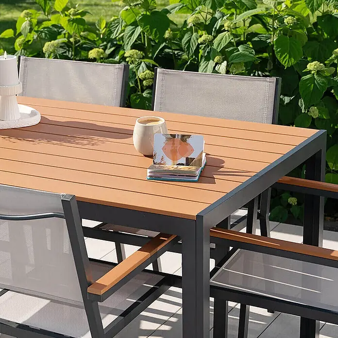 Home Deluxe Gartentisch CANTOS - L x B x H: 150 x 90 x 75 cm, Anthrazitgrau - Outdoor-Essgruppe: Tisch mit Holzoptik-Platte und dunklem Gestell, graue Netzstühle mit Holzarmlehnen auf einer Terrasse.