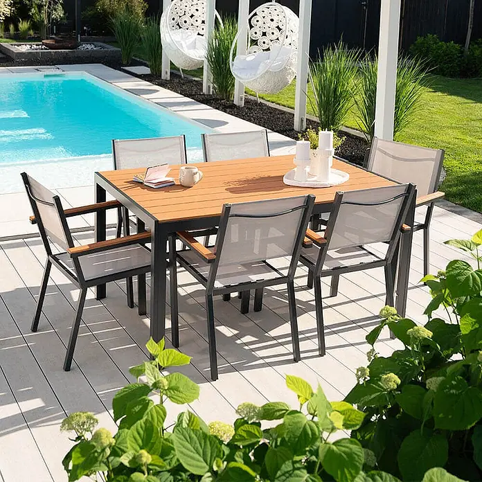 Home Deluxe Gartentisch CANTOS - L x B x H: 150 x 90 x 75 cm, Anthrazitgrau - Gartensitzgruppe: dunkel gerahmter Tisch mit Lamellenplatte und grauen Netzstühlen, auf einer Terrasse am Pool.