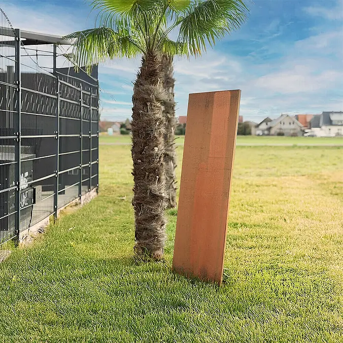 Home Deluxe Sichtschutzelement AURA 148 x 50 cm - B x H: 50 x 148 cm, Rost - Rechteckige rostige Metallplatte lehnt an einer Palme.