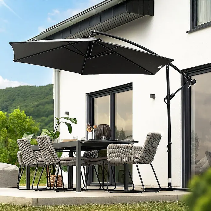 Home Deluxe Ampelschirm SOLANA - Anthrazit - Schwarzer Freiarmschirm spendet Schatten über einer modernen grauen Outdoor-Essgruppe auf der Terrasse.
